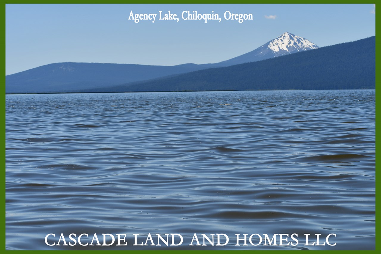 this photo was taken at the shoreline at agency lake, with snow-capped mt. mclaughlin is in the background. agency lake is a natural lake, considered to be part of the upper klamath lake, only  connected by a narrow channel. it is fed by the wood river, one of the many rivers in the area.