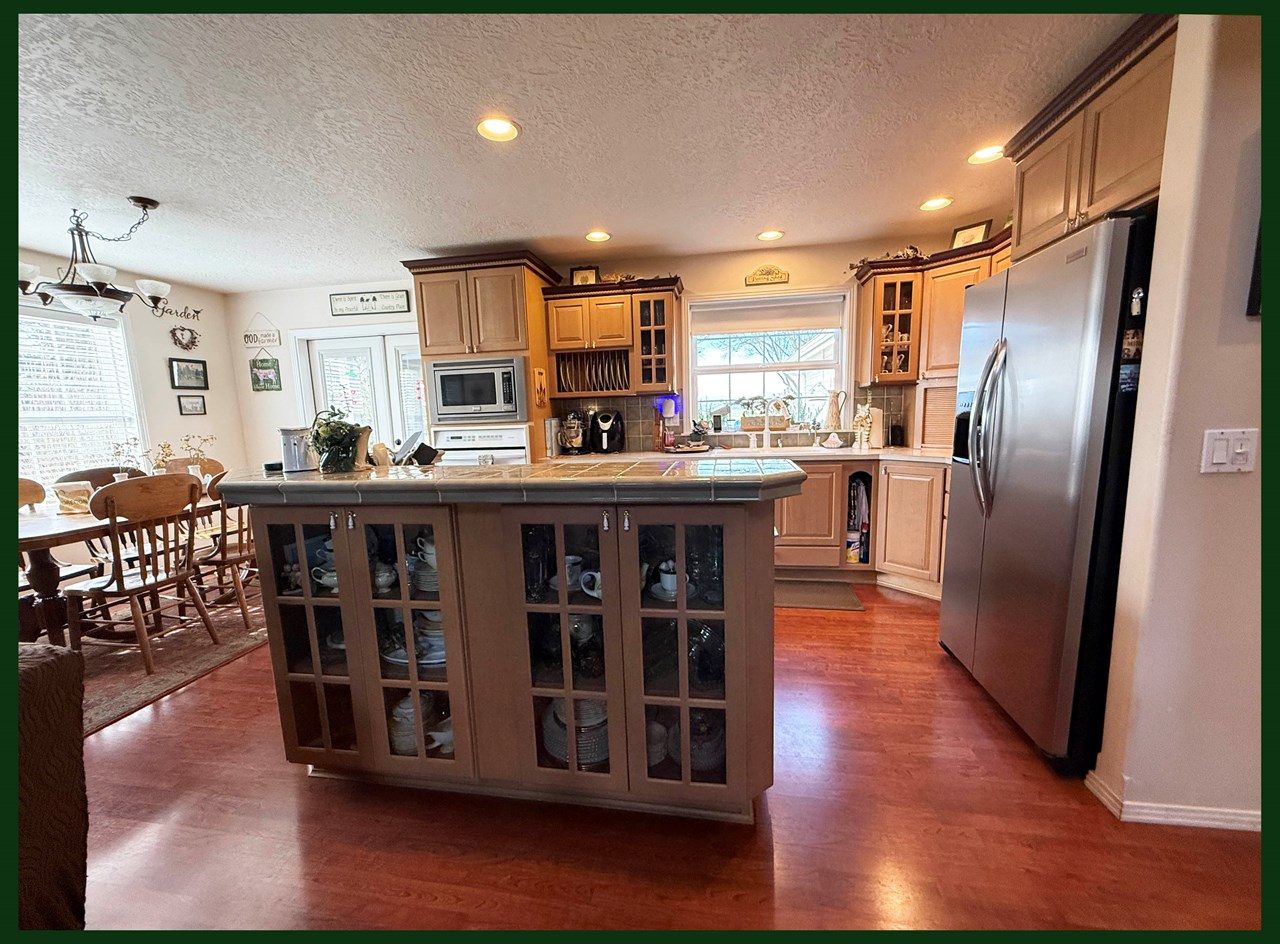 open kitchen and dining room featuring custom cabinetry and natural light