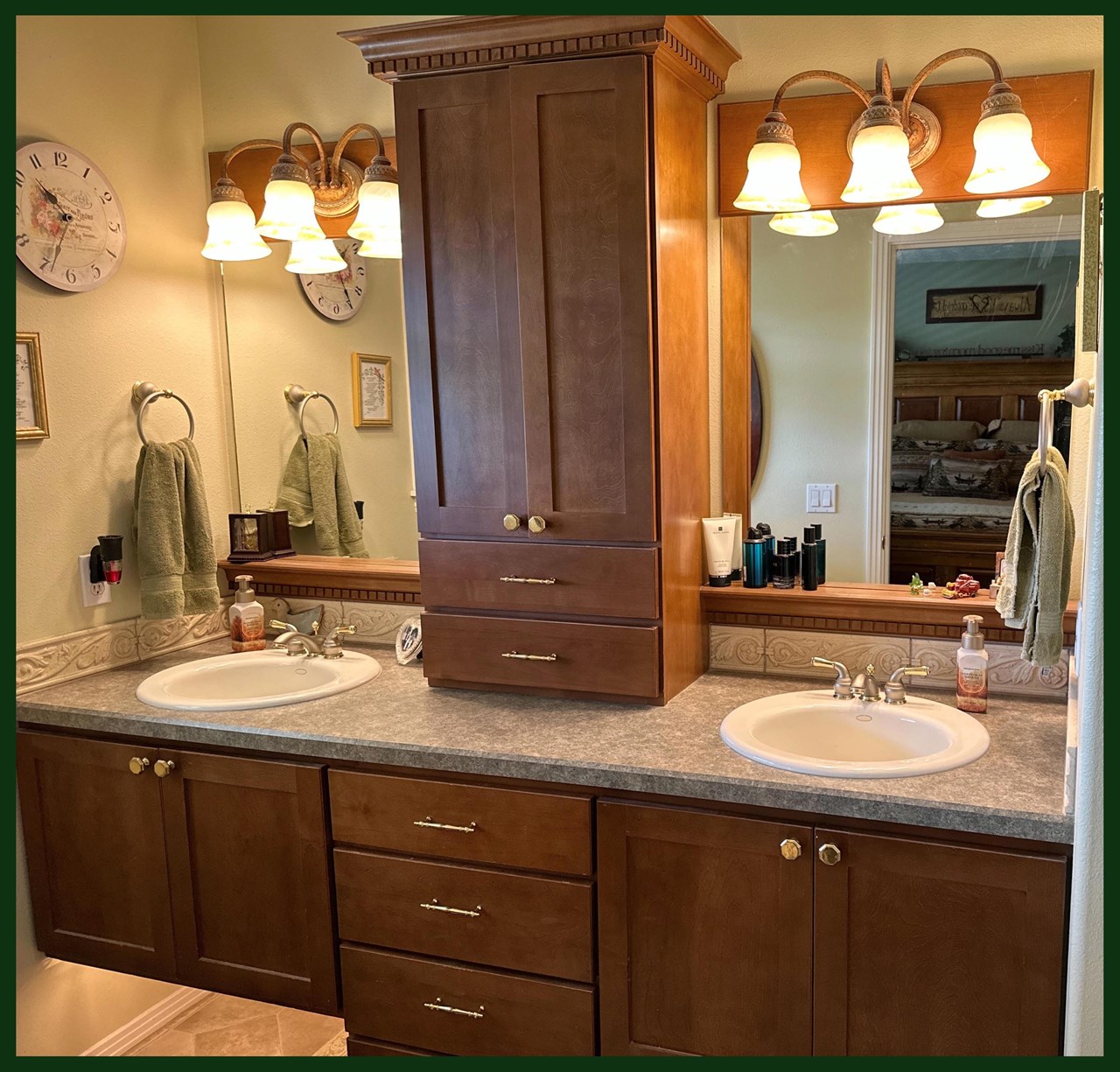 en suite bathroom with double sinks, custom cabinetry