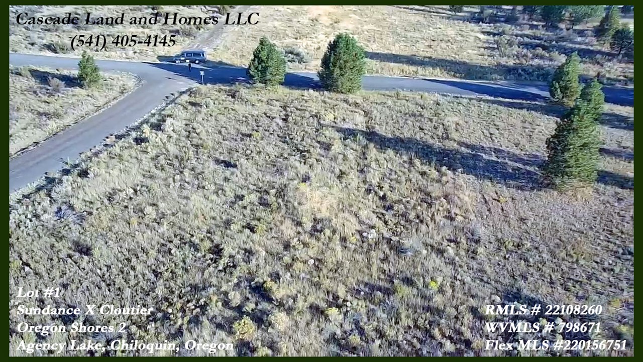 this is a drone photo taken from above the property looking down at the intersection of sundance and cloutier dr. the property is mostly flat with a slight slope uphill from sundance drive.